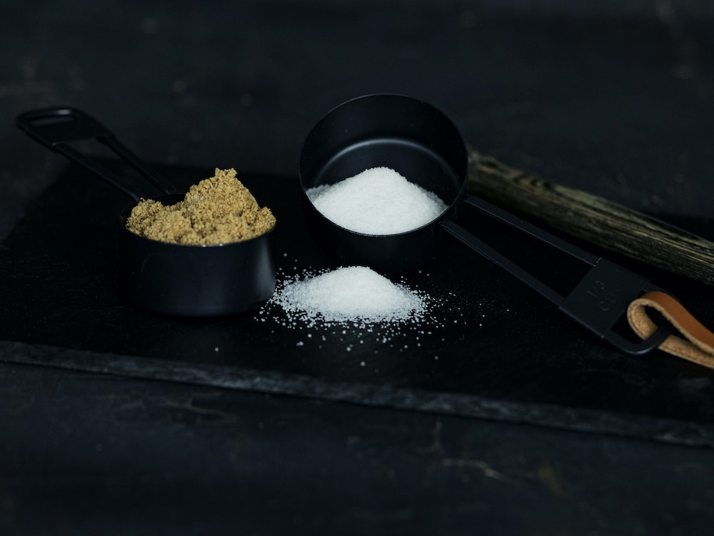 Measuring cups with brown and granulated sugar for simple syrup recipe