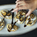 Hand holding brussels sprout crostini