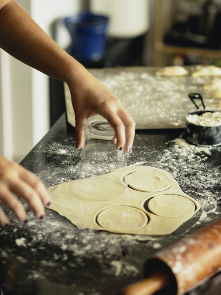 Hands cutting pierogi dough